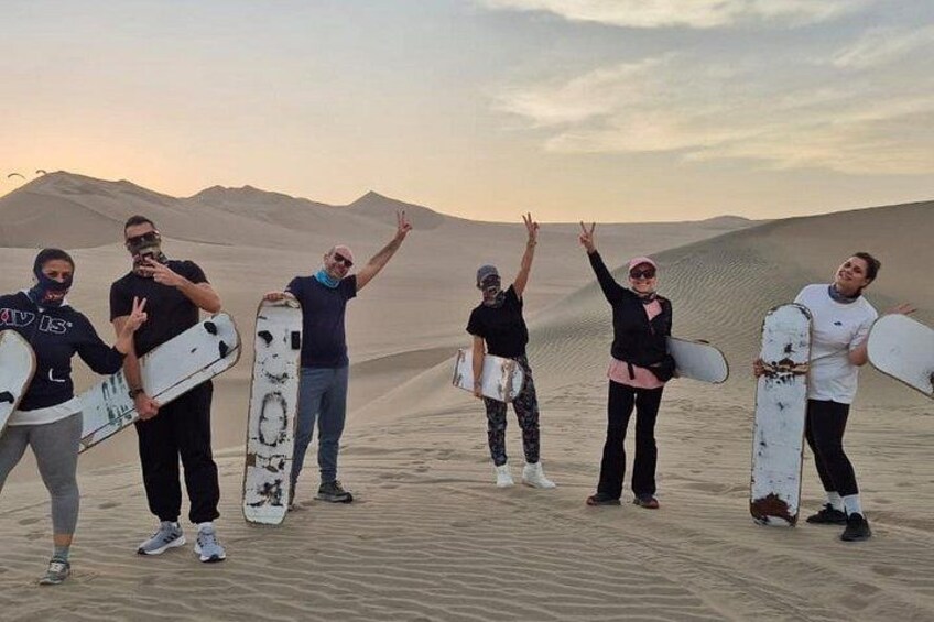 A group of people with snowboards in a desert landscape. 3