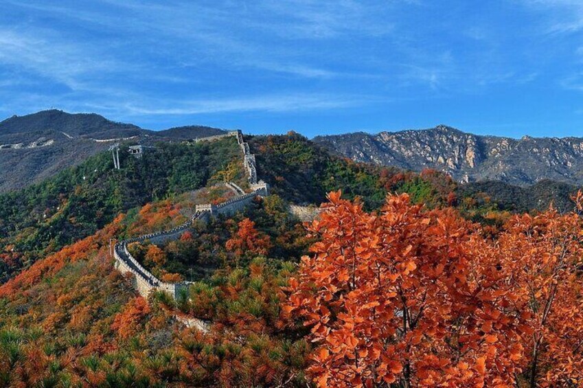 The Great Wall of China winding through a mountainous landscape with autumn foliage. 3