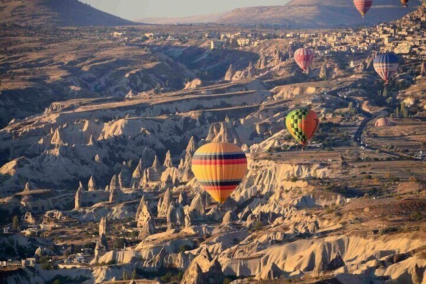 Des montgolfières survolent un paysage rocheux parsemé de formations rocheuses uniques. 1
