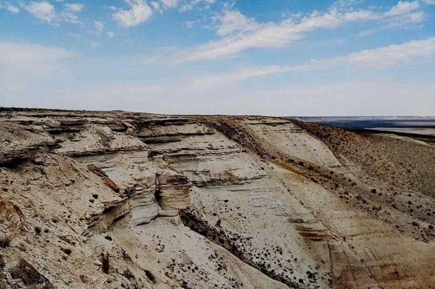 Et stort, eroderet landskab med lagdelte sedimentære klippeformationer. 4