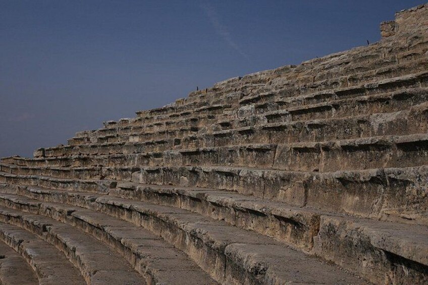 A tiered stone amphitheater with multiple levels of seating. 2