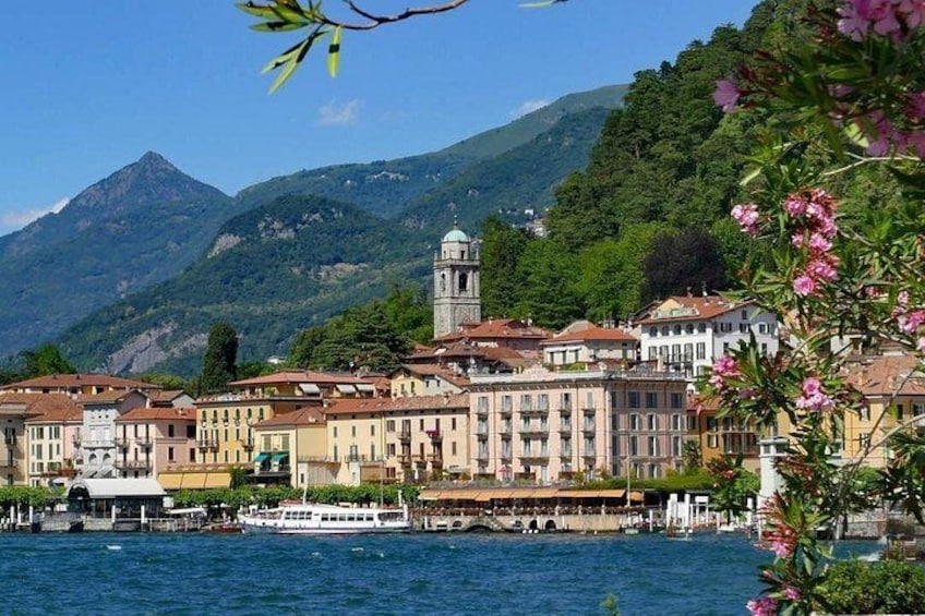 A waterfront town with historic buildings, a church tower, and a boat docked at the pier. 4