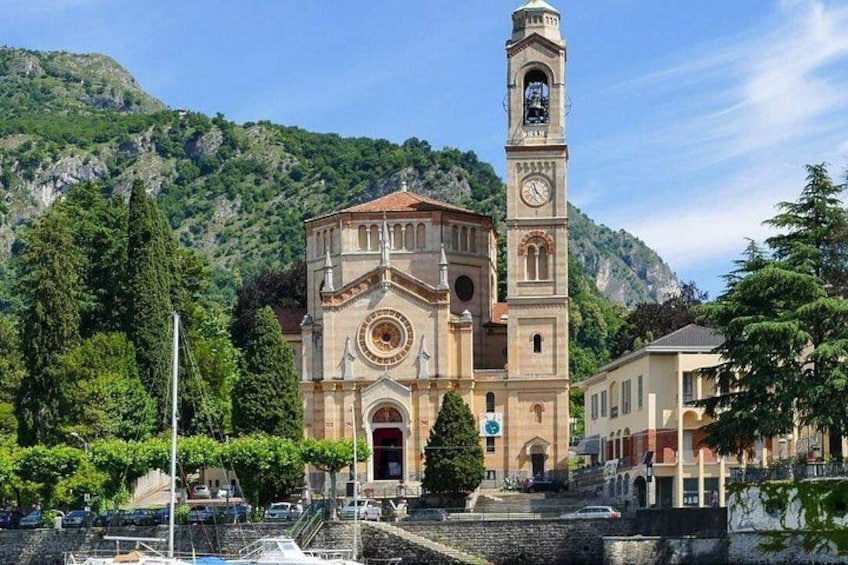 A church with a bell tower, surrounded by trees and a mountainous backdrop. 2