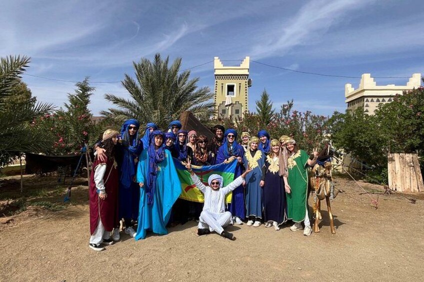 A group of people in traditional attire posing in front of a castle-like structure. 3