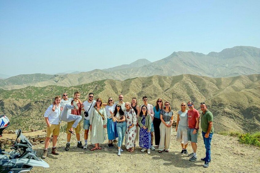 A group of people standing on a hill with a mountainous landscape in the background. 4
