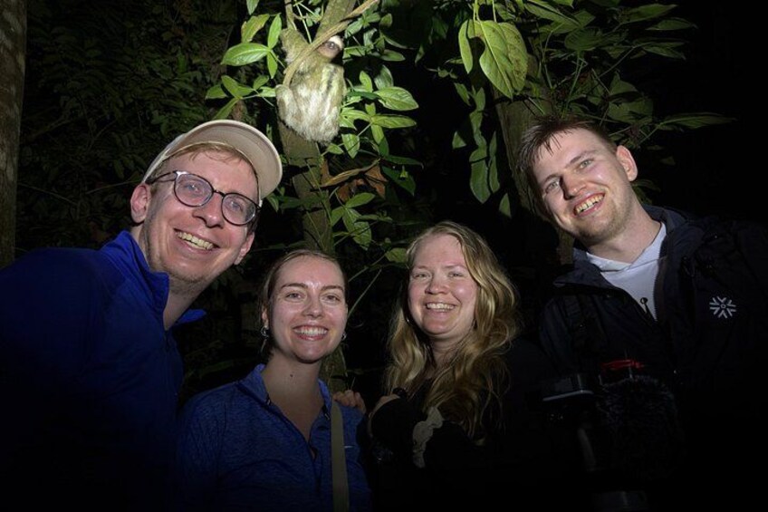 Cuatro personas posando con un árbol y un objeto colgante. 3
