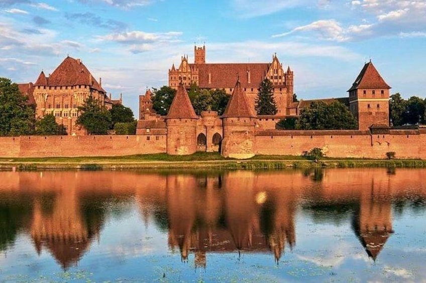 Un castello storico con un fossato, circondato da un muro merlato. 3