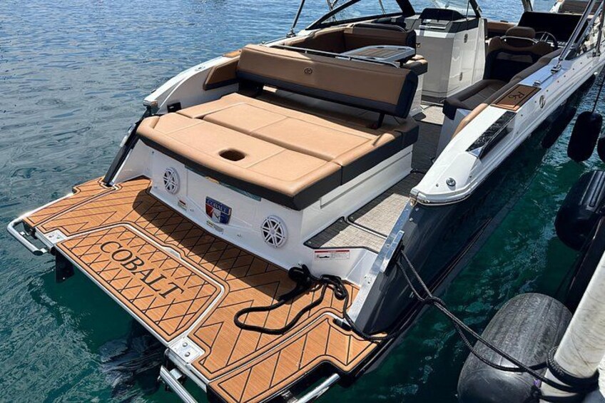 A boat with a wooden deck, a cabin, and a name 'Cobalt' on the side. 4