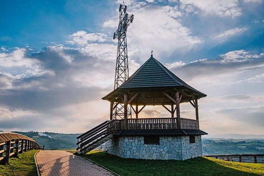 A stone structure with a wooden roof and a metal tower. 3