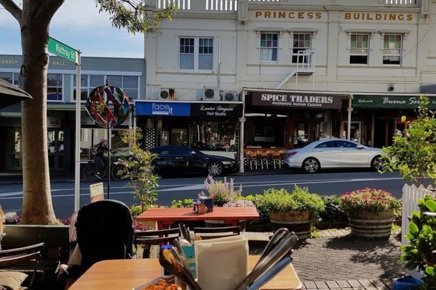 A street with a restaurant, a car parked in front, and a building labeled 'Princess Buildings'. 3