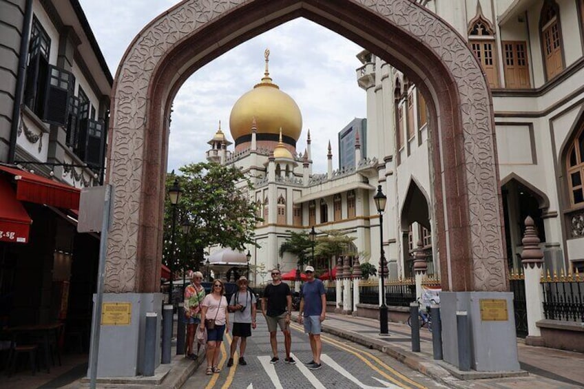 A large archway with intricate designs, leading to a building with a golden dome. 1
