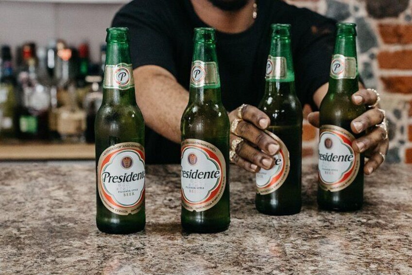 Quatre bouteilles de bière Presidente sur un comptoir. 4