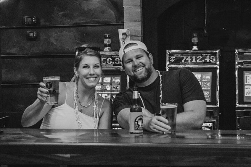 Deux personnes sont assises au bar, devant des boissons, un juke-box et une horloge numérique qui affiche l’heure. 2