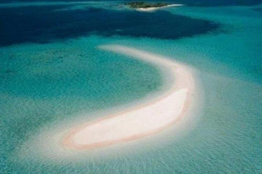 A clear aerial view of a crescent-shaped sandbar surrounded by turquoise waters. 2