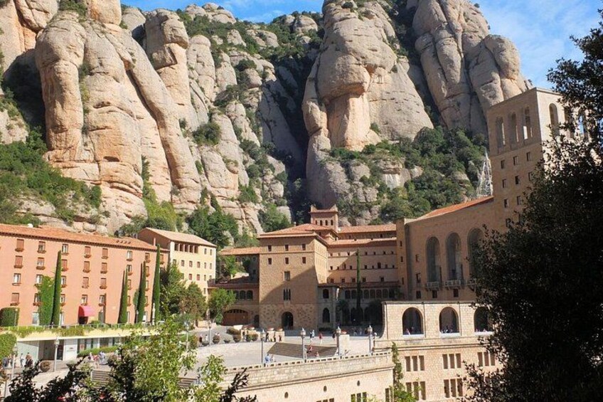 A town with buildings in front of a large rock formation. 2