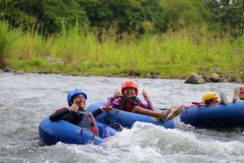 Menschen, die auf einem Fluss mit viel Grün an den Ufern eine Rafting-Tour machen. 4