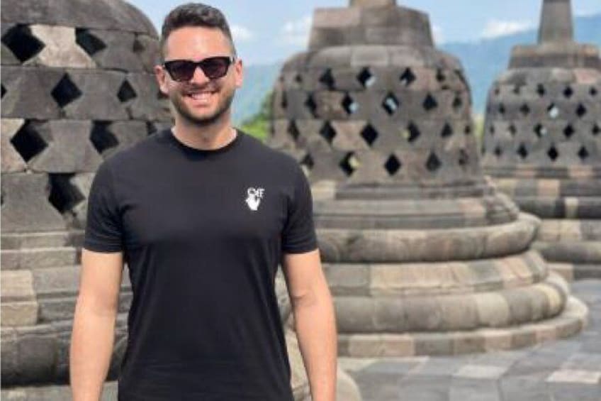 Una persona de pie frente a antiguas estructuras de piedra. 5