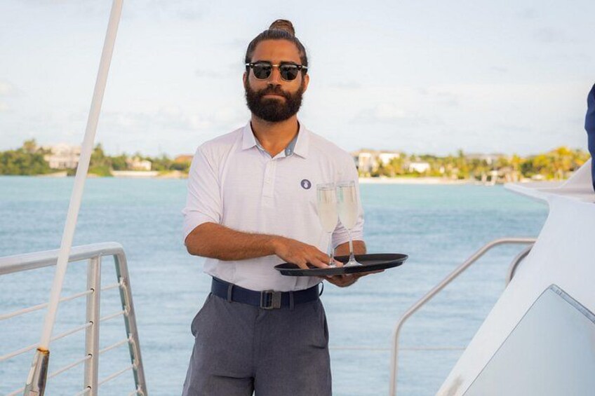 A person on a boat holding a tray with a glass. 3