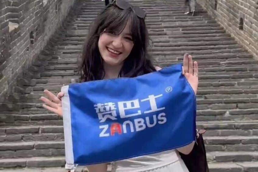 A person holding a blue bag with foreign text and the word "ZANBUS" on it. 3