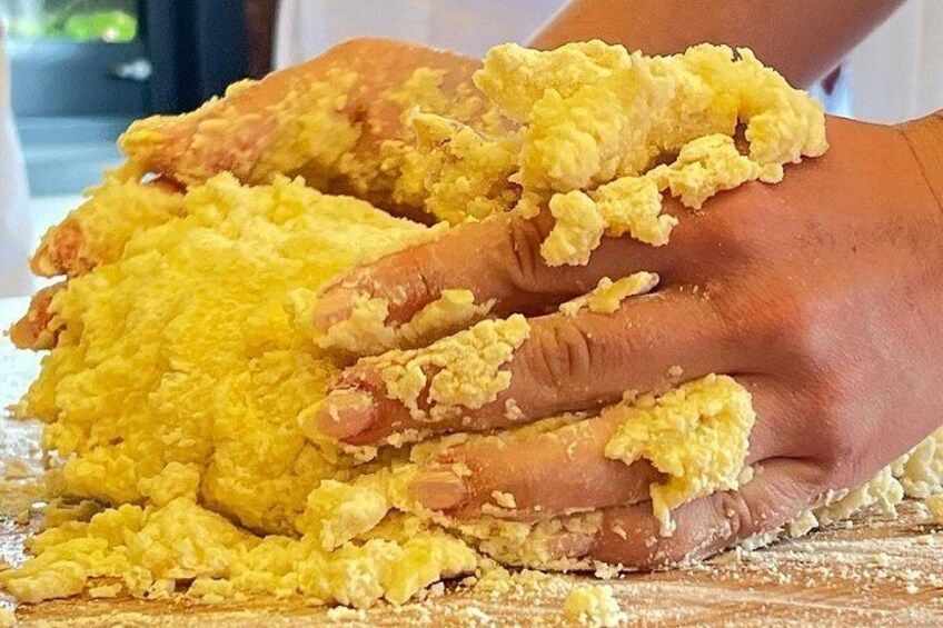 Hands kneading dough on a wooden surface. 3