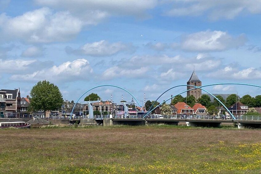 A river with a bridge, a church, and residential buildings. 2