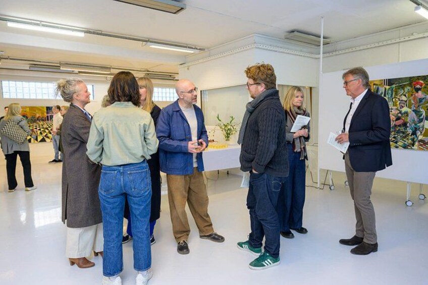 A group of people in a modern indoor space with white walls and a ceiling with linear lights. 4