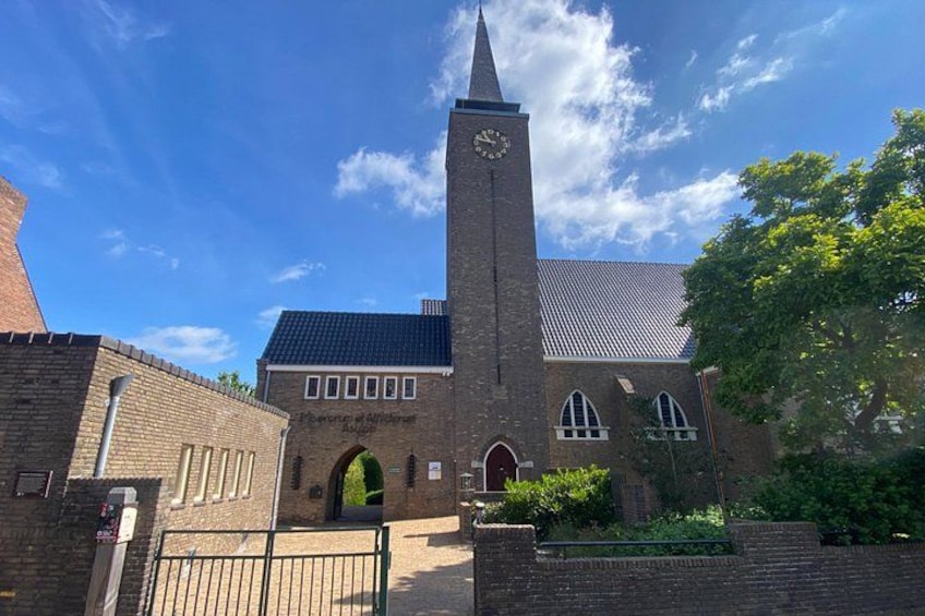 A church with a tall tower, a clock, and a brick facade. 3