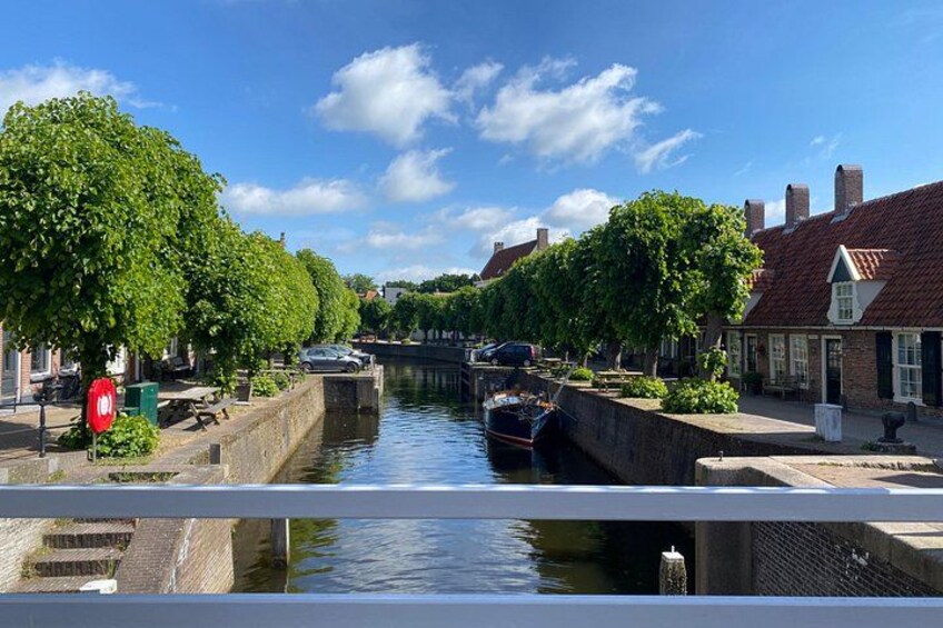 A canal with boats, trees, and buildings along the banks. 2