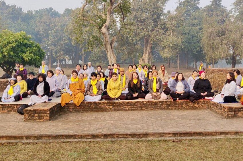 A group of people sitting on stone steps outdoors in a park. 5