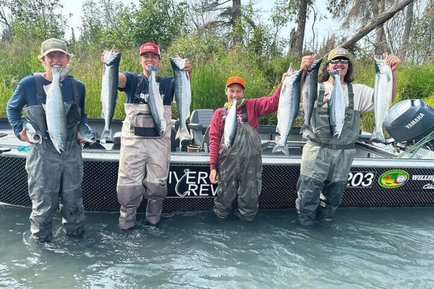 Four people holding fish on a boat. 5