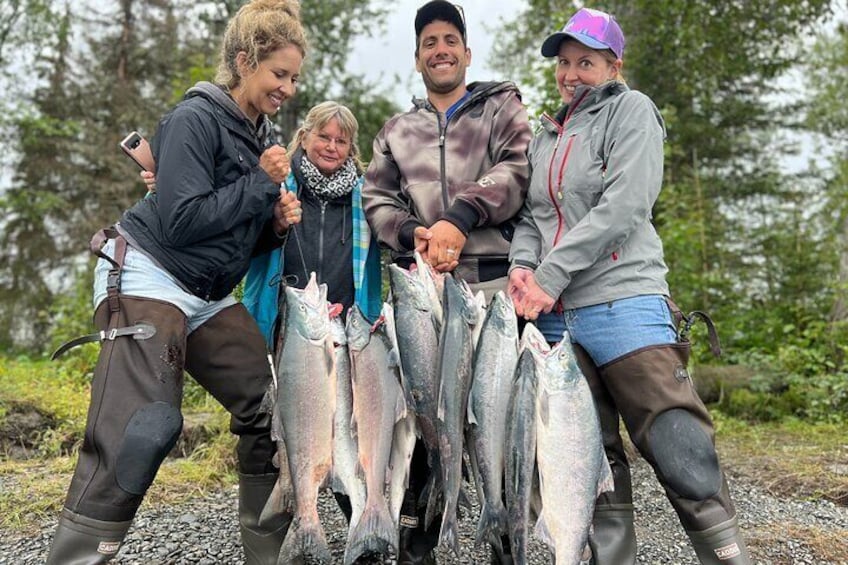 A group of people holding several fish. 2