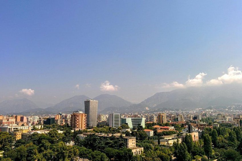 Paesaggio urbano con edifici, una catena montuosa e cielo sereno. 3