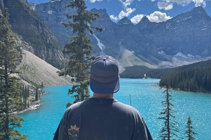A person standing with a mountainous landscape in the background. 2