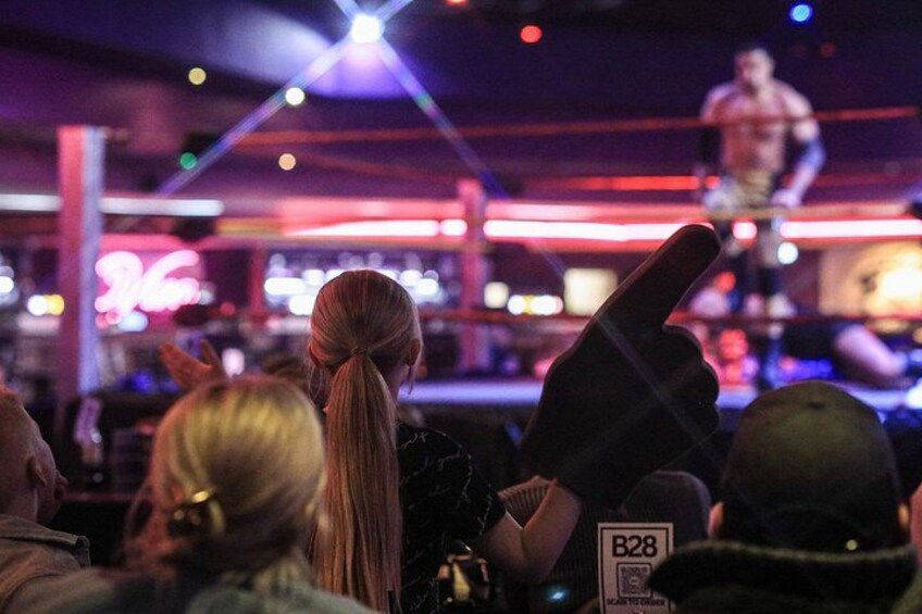 A person standing on a stage with a crowd in the foreground. 4