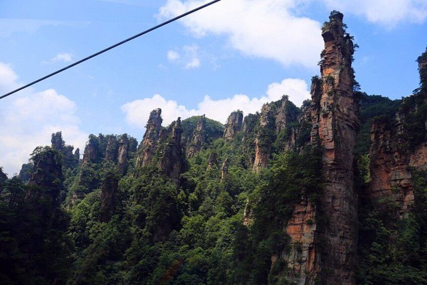Un paisaje montañoso con altas formaciones rocosas y densa vegetación verde. 4