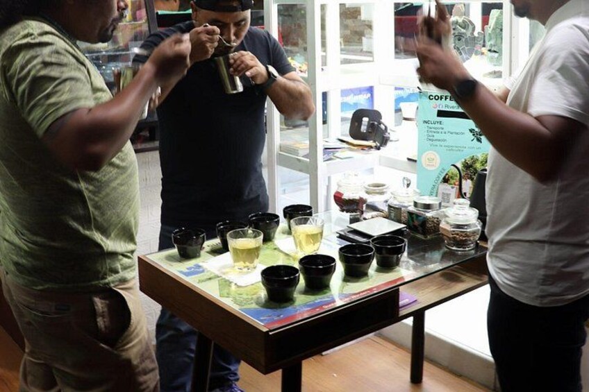 Tre persone in un caffè, con un espositore di tazze e contenitori per il caffè. 4