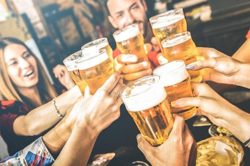 A group of people toasting with beer glasses. 2