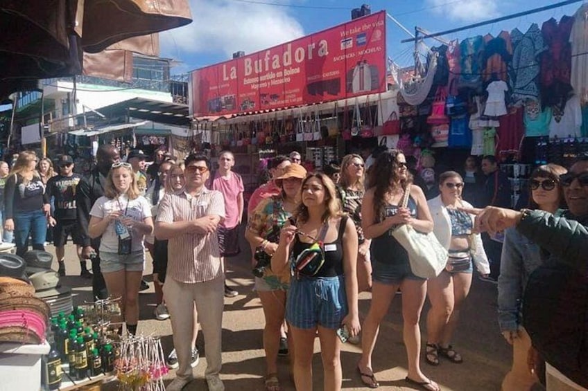 Un mercado al aire libre concurrido, con gente caminando y vendedores ofreciendo productos. 5