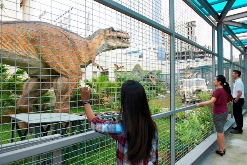 Eine Dinosaurierausstellung mit einem großen Dinosauriermodell hinter einem Zaun. 5