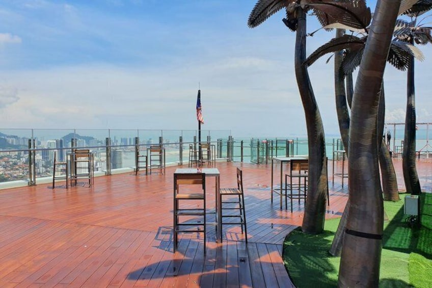 Eine Dachterrasse mit Holzboden, Stühlen und einer amerikanischen Flagge. 4