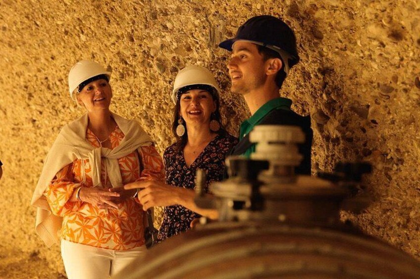 Three people wearing hard hats and a large mechanical device in a rocky environment. 2