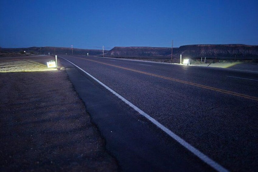 A road at dusk with streetlights and a flat landscape. 4