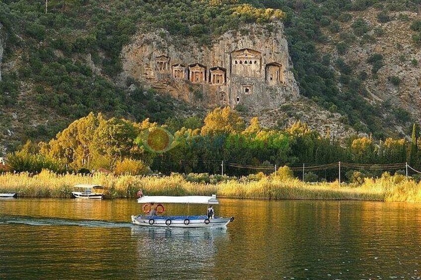 A river with boats, a rocky cliff with ancient ruins, and autumn foliage. 3