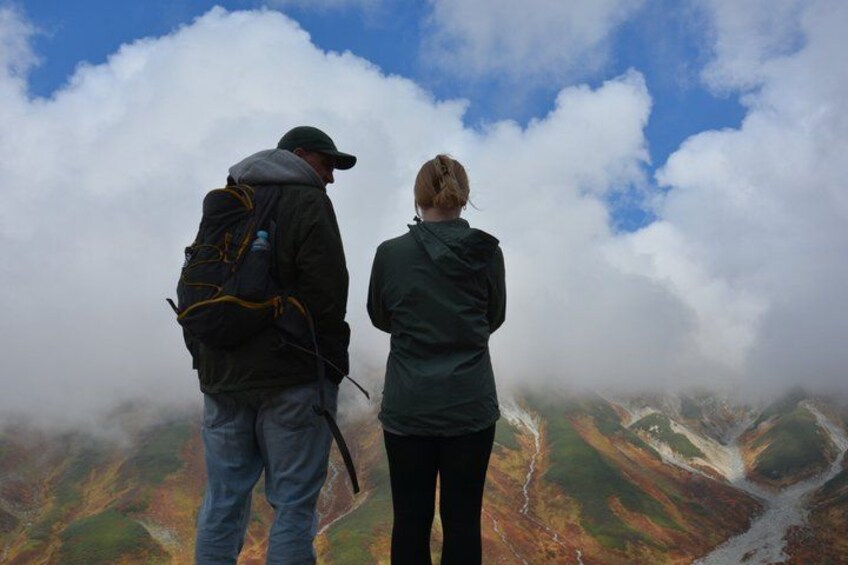 Dos personas sobre un filo de montaña, con vista a un valle y un río. 4