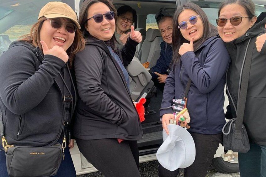 A group of people standing in a vehicle, some holding items. 4