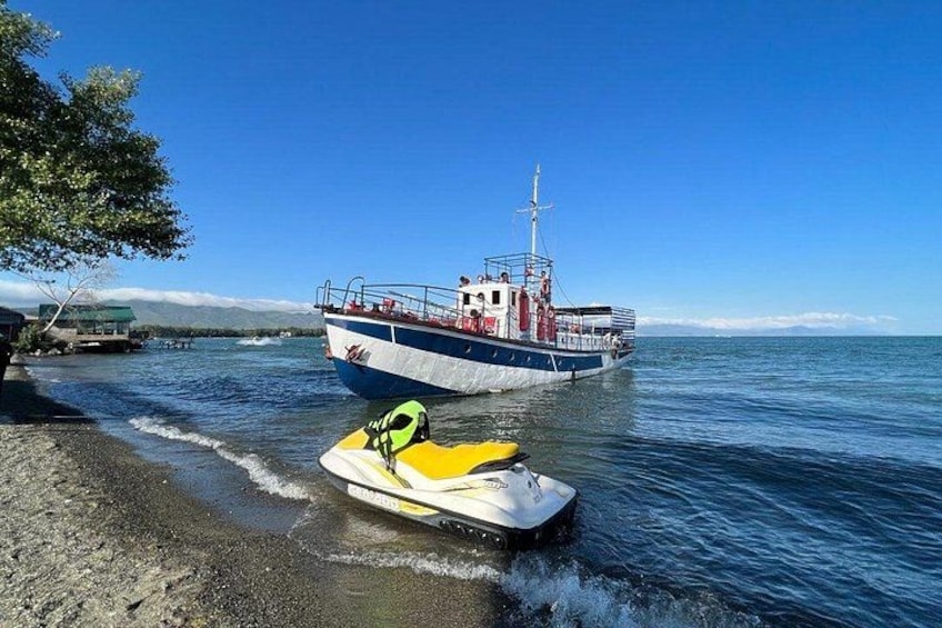 Een jetski op het strand, met een boot op de achtergrond. 2