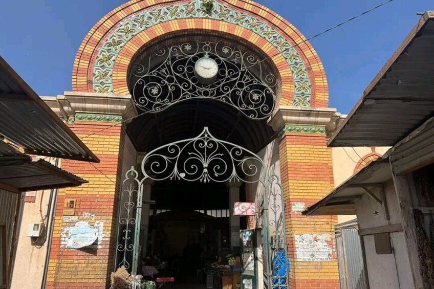 Une entrée richement décorée, ornée d’une horloge, et entourée d’immeubles en briques. 2