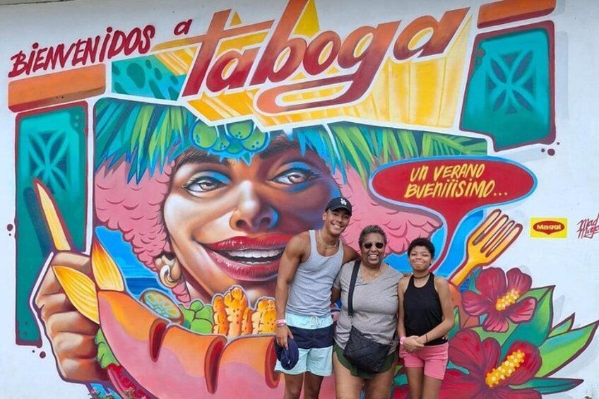 A colorful mural with a tropical theme, including a hand holding a fruit and a tropical flower. 2