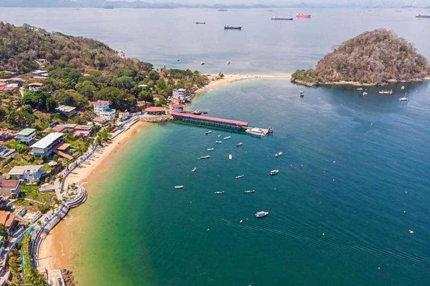 A coastal town with a beach, boats, and a peninsula. 2