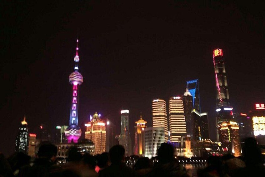 A city skyline at night with illuminated buildings and a prominent tower. 4
